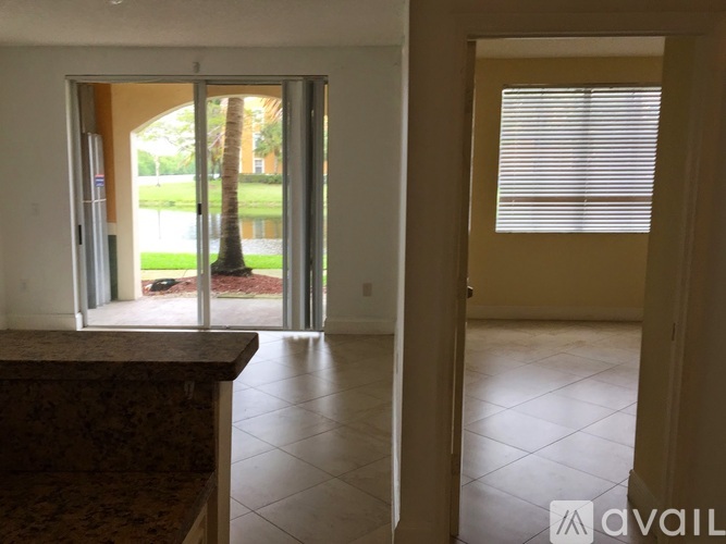A room with a marble countertop and a door leading to a patio with a tree.