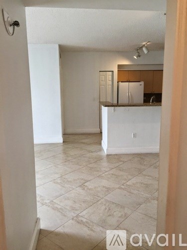 A kitchen area with white cabinets and a countertop.