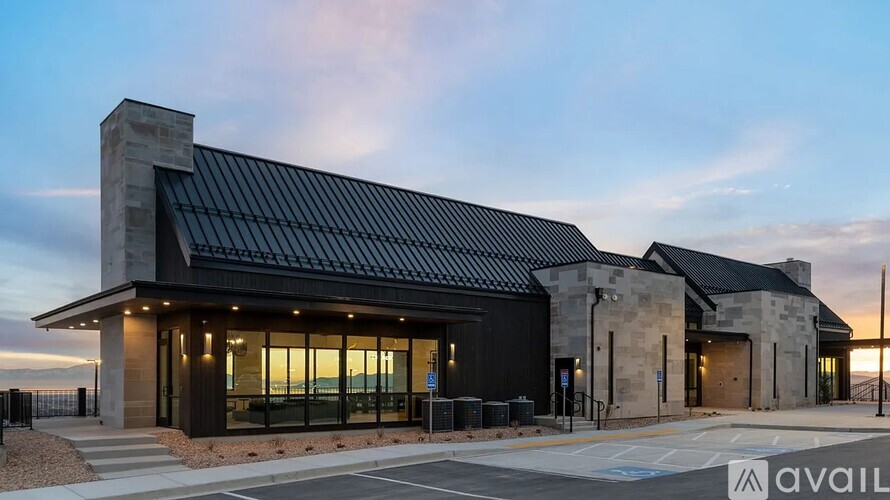 A modern building with a black roof and glass windows is shown.