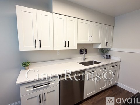 A kitchen with white cabinets and a stainless steel refrigerator.