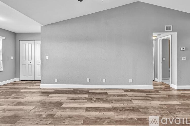 A spacious room with a checkered floor and two white doors.
