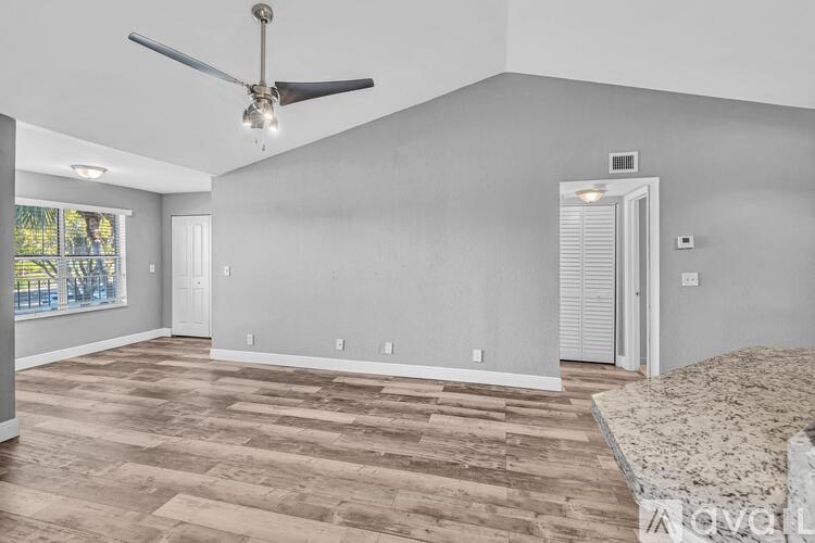 A living room with a ceiling fan and light fixture.
