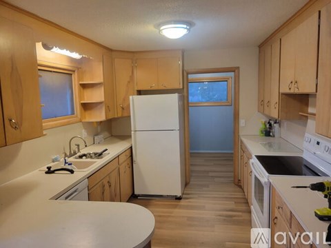 A kitchen with wooden cabinets and a white refrigerator.