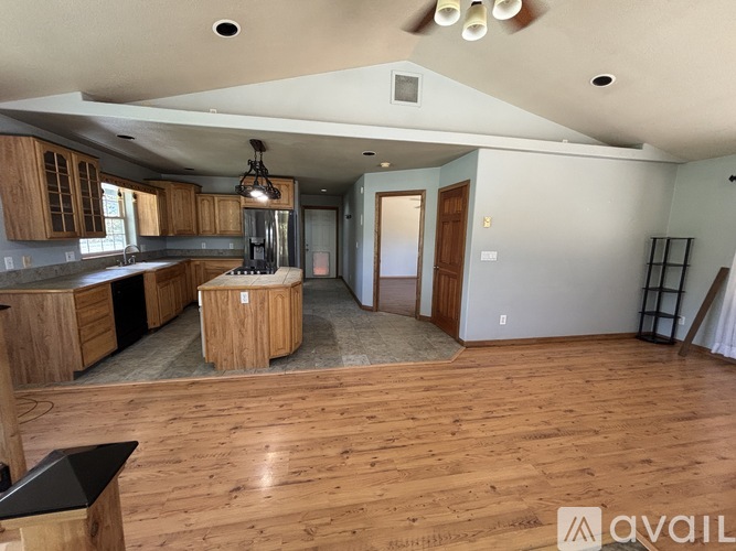 A spacious kitchen with wooden floors and cabinets.