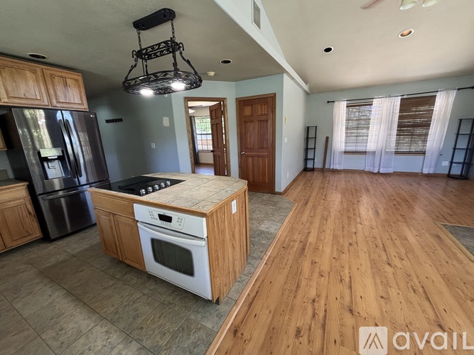 A kitchen with wooden cabinets and a black fridge.