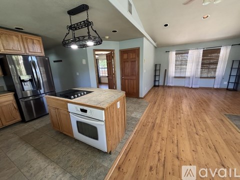 A kitchen with wooden cabinets and a black fridge.