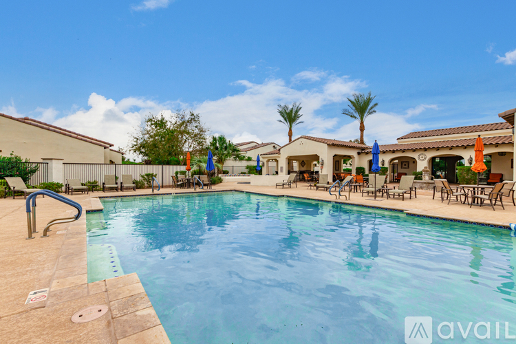 A large swimming pool surrounded by lounge chairs and umbrellas.