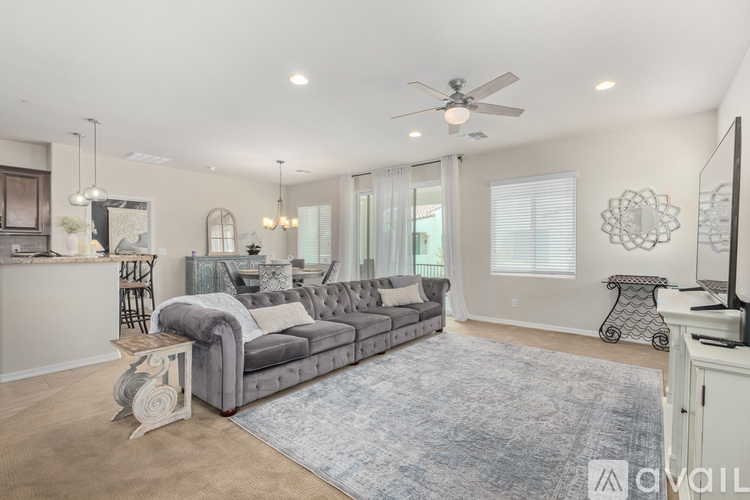 A living room with a grey couch and a blue rug.