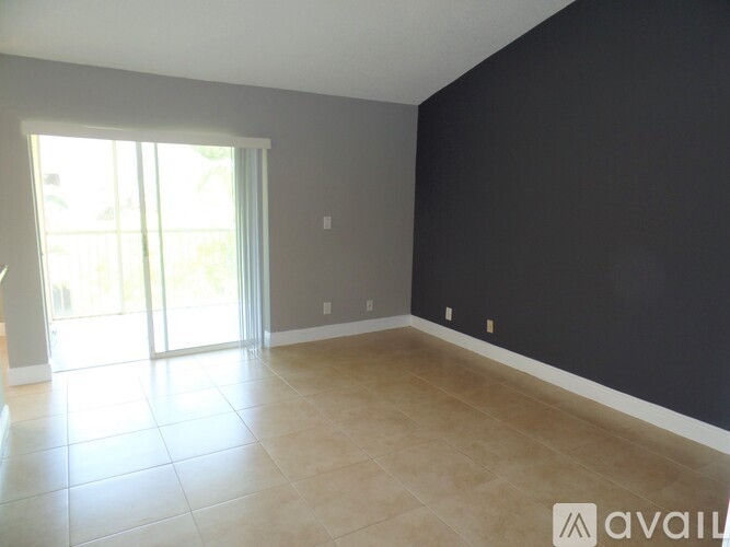 A spacious room with a sliding glass door leading to a balcony.