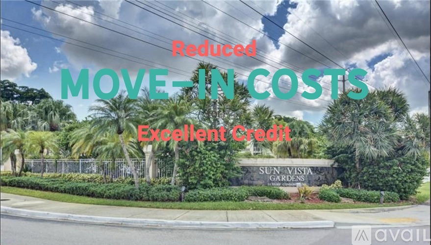 A sign for Sun Vista Gardens is displayed in front of a row of palm trees.