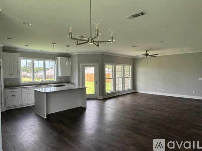 A spacious kitchen and living room with hardwood floors and a large island.