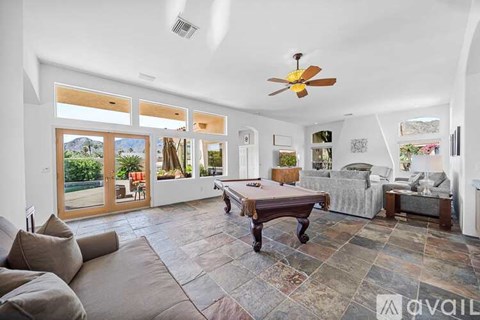 A living room with a brown table and a grey couch.