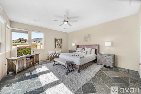 A bedroom with a large bed and a ceiling fan.
