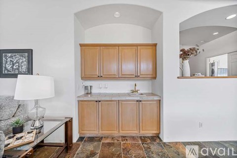 A kitchen with wooden cabinets and a marble countertop.