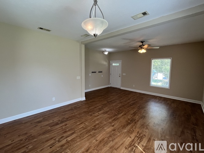 A room with wooden floors and a ceiling fan.