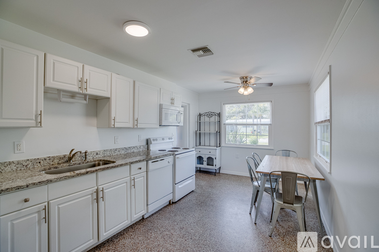 A kitchen with white cabinets and a granite countertop.