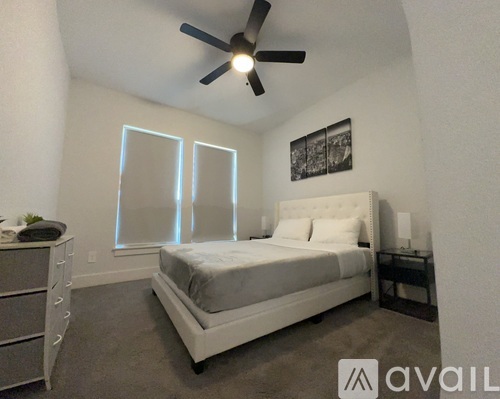 A bedroom with a bed, nightstand, and a ceiling fan.