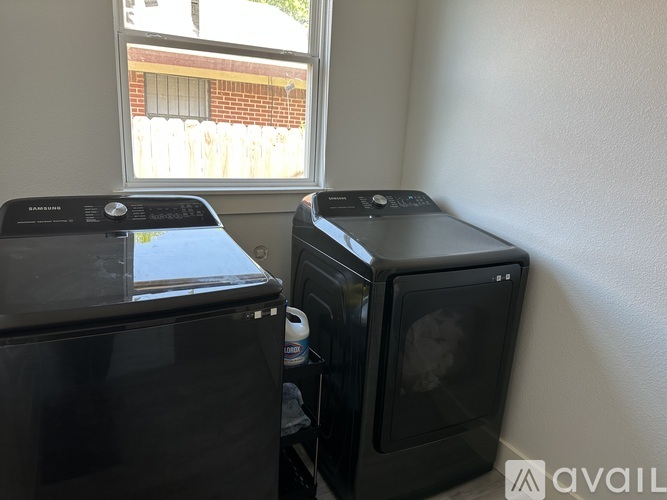 Two black microwaves are placed next to each other in a kitchen.