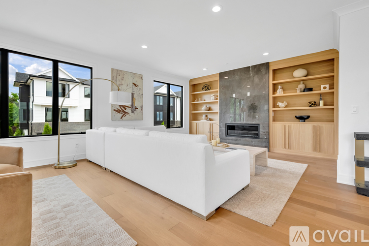 A modern living room with a white sofa and a fireplace.