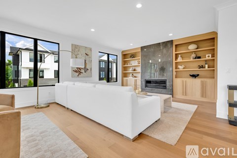 A modern living room with a white sofa and a fireplace.