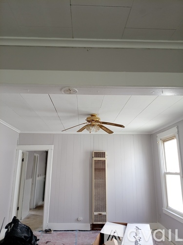 A room with a ceiling fan and a window.