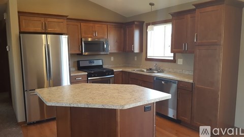 A kitchen with wooden cabinets and a granite countertop.