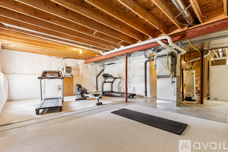 A spacious room with a treadmill, exercise bike, and other workout equipment.