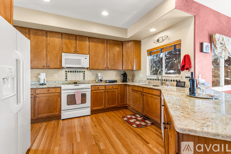 A kitchen with wooden cabinets and a marble countertop.