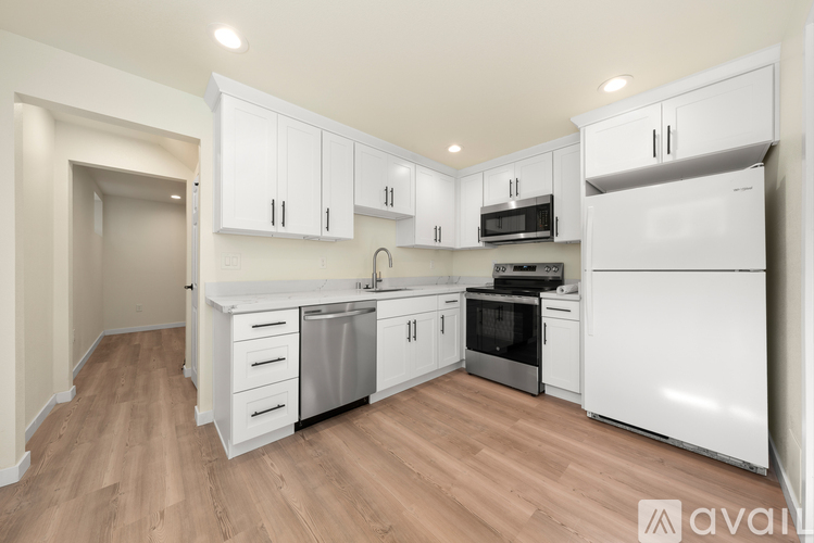 A kitchen with white cabinets and appliances.