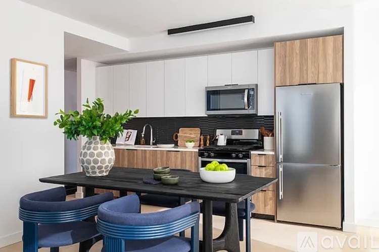 A modern kitchen with a black table and blue chairs.