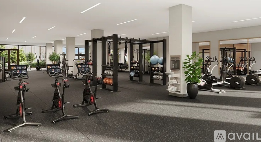 A gym with various exercise equipment and a large mirror on the wall.