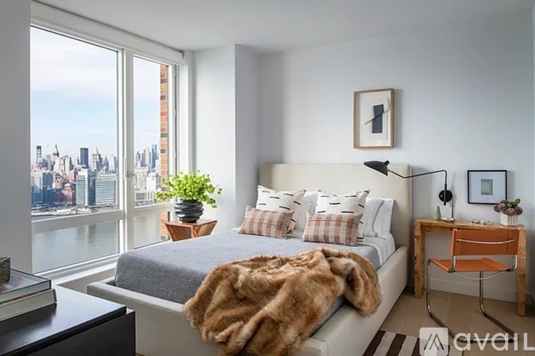 A bedroom with a large bed and a view of the city.