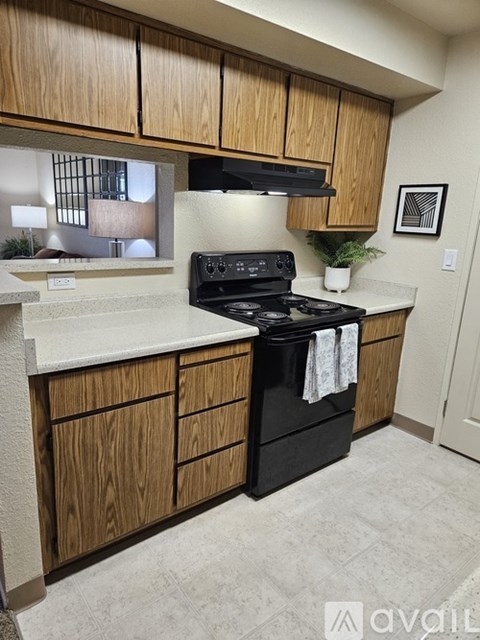 A kitchen with wooden cabinets and a black stove top oven.