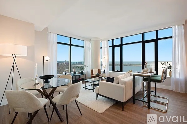 A modern living room with a glass table and white chairs.