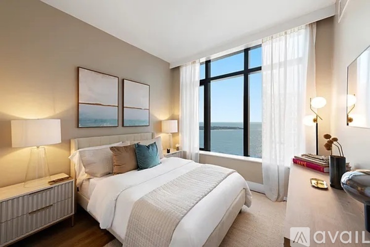 A bedroom with a large bed and a view of the ocean.