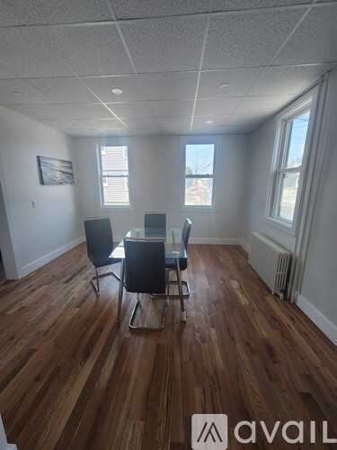 A room with wooden floors and two chairs.