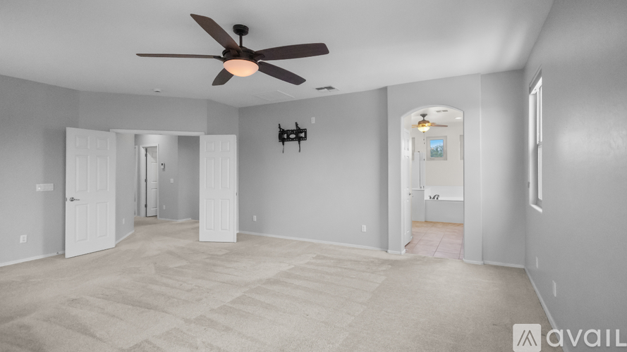 A spacious room with a ceiling fan and carpeted floor.