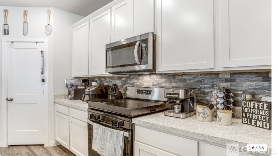 A kitchen with a stove top oven and a microwave above it.