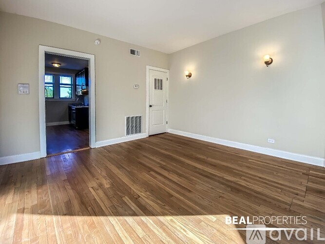 A room with wooden flooring and two wall-mounted lights.