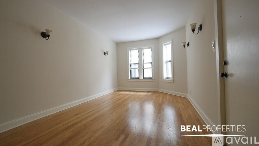A room with wooden floors and a window is available for rent.