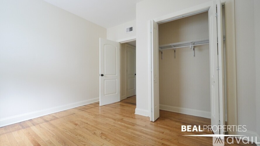 A room with a white door and a white wall with a shelf.