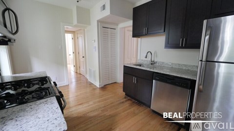 A kitchen with a stove top oven and a refrigerator.