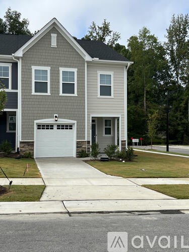 A two-story house with a garage and a driveway.