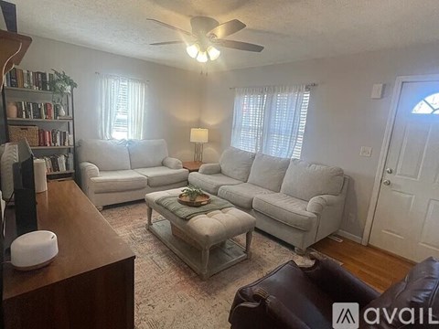 A living room with a brown leather couch and a glass coffee table.