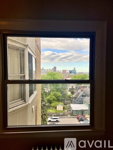 A window with a view of a city skyline and buildings.