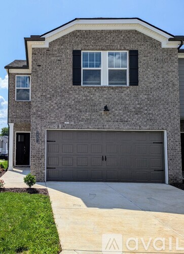 A house with a grey garage door and a black door.