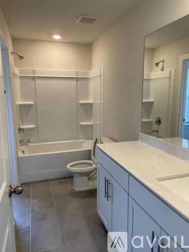 A bathroom with a toilet, sink, and shelves.