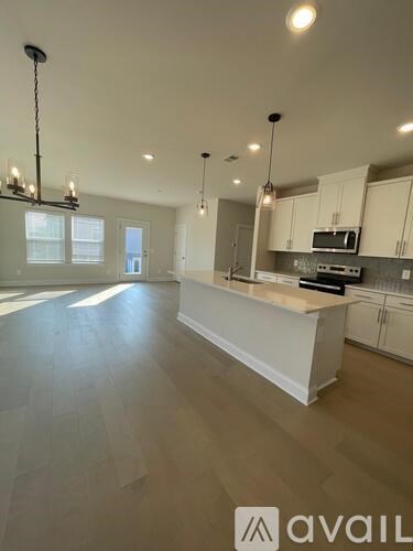 A spacious kitchen with white cabinets and a central island.