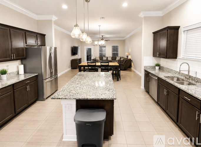 A kitchen with a granite countertop and a dining table with chairs.