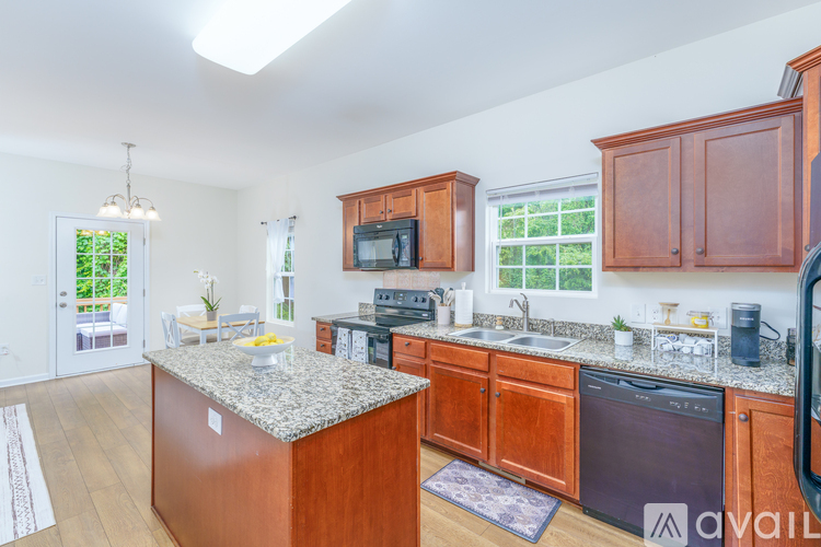 A kitchen with wooden cabinets and a granite countertop.